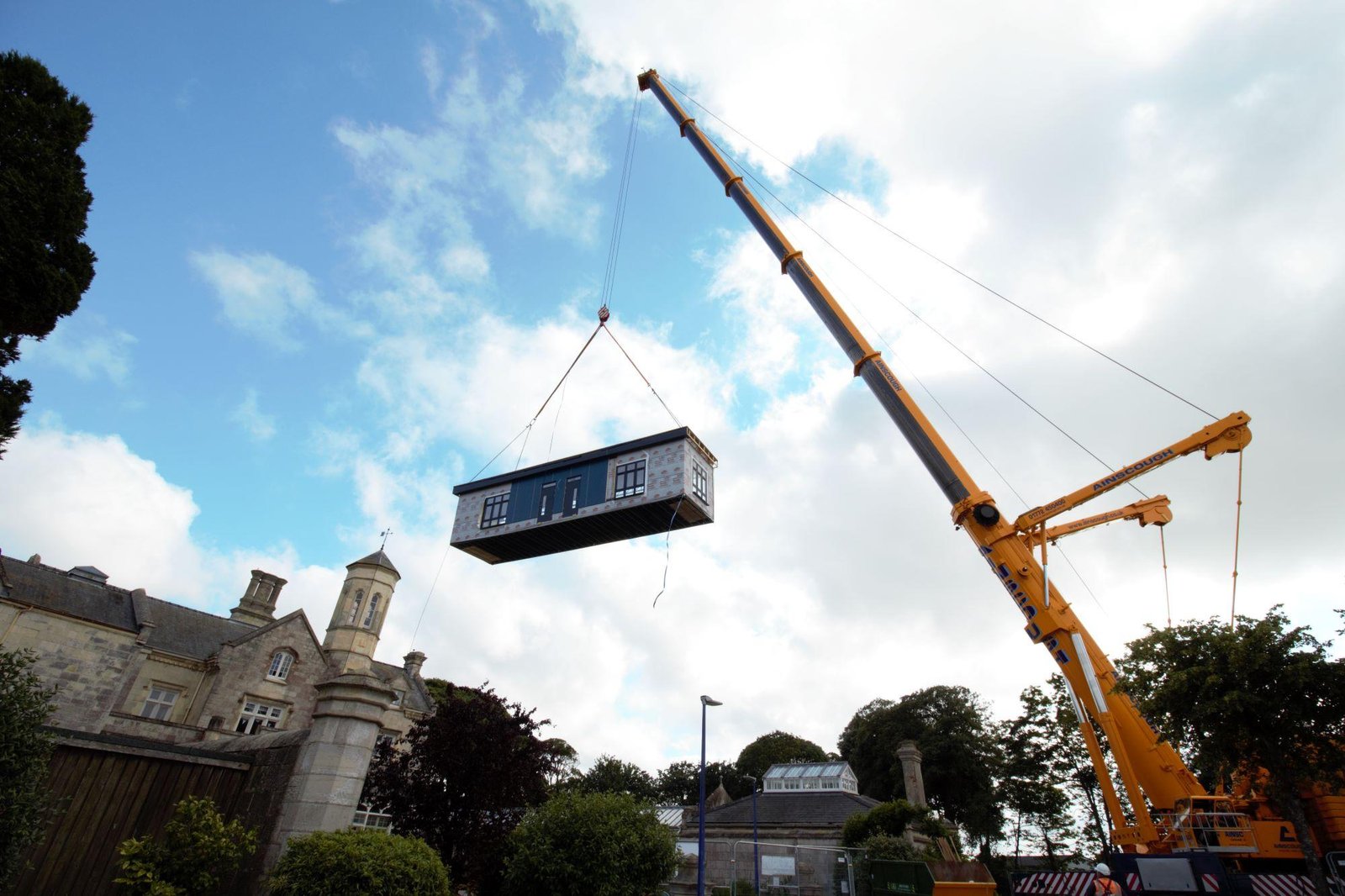 Modular building module lifted and carefully positioned by crane, part of the Modern Methods of Construction process for rapid on-site assembly