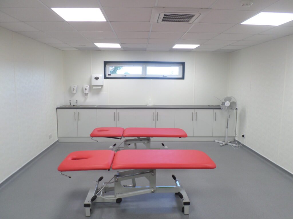 Modular sports facility treatment and rehabilitation room â designed for athlete recovery Interior of a modular sports facility treatment room with therapy couches and medical equipment for rehabilitation