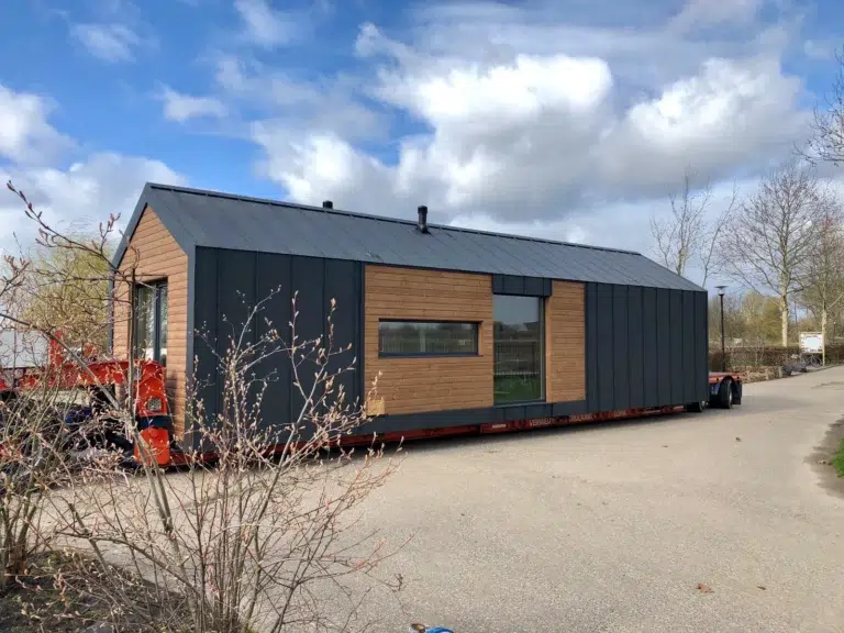The Grove modular luxury lodge in the UK with gable roof, sheet metal and woodboard facade, two bedrooms, open kitchenette, and living area – spacious prefab holiday home for families.